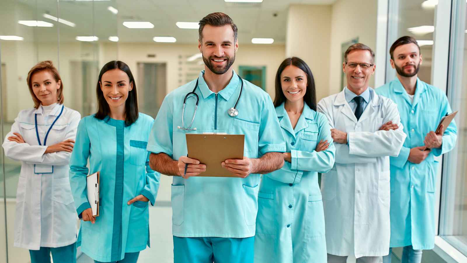 Uśmiechnięci lekarze stojący na korytarzu w szpitalu.